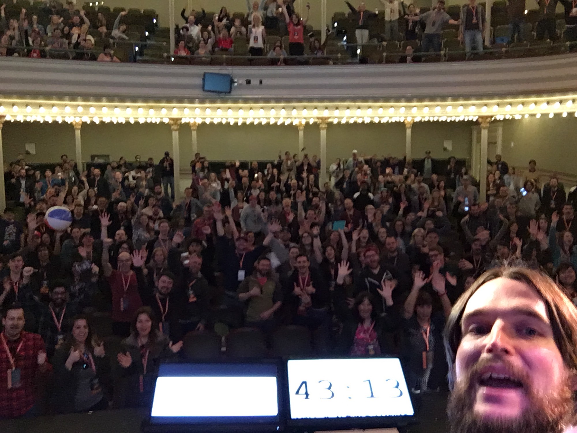 Photo of a selfie I took on stage with an excited audience in background